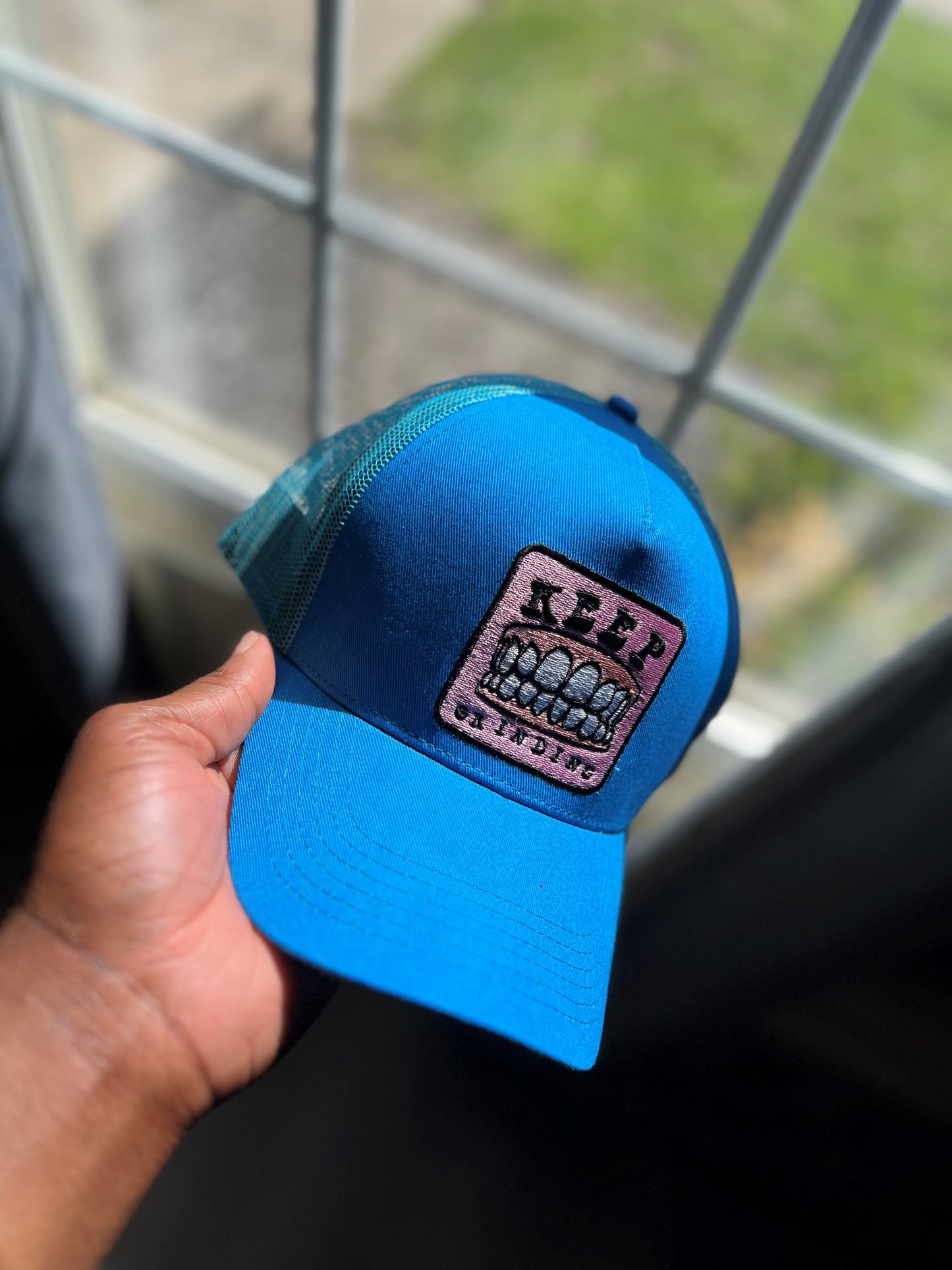 DyLN Rd Trucker Hat KEEP GRINDING embroidery